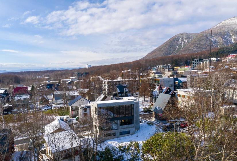 A 3 story concrete home with a dusting of snow.