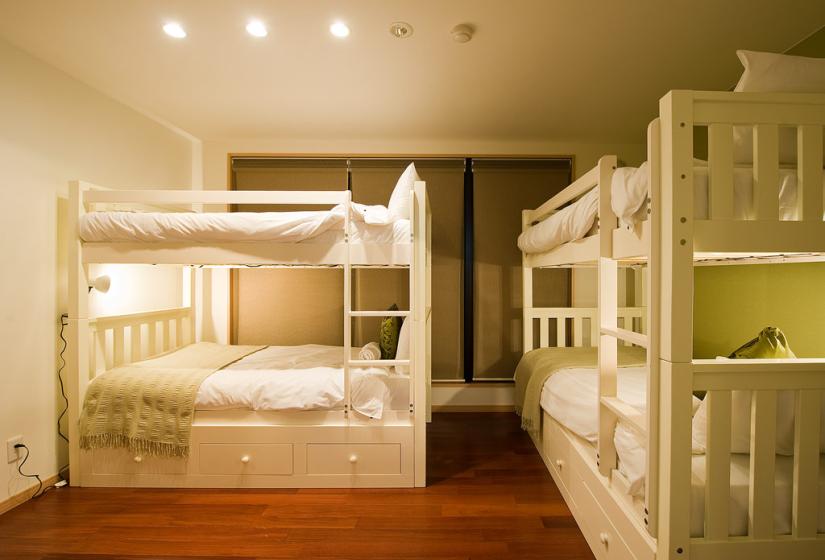 2 bunk beds with white and green linen