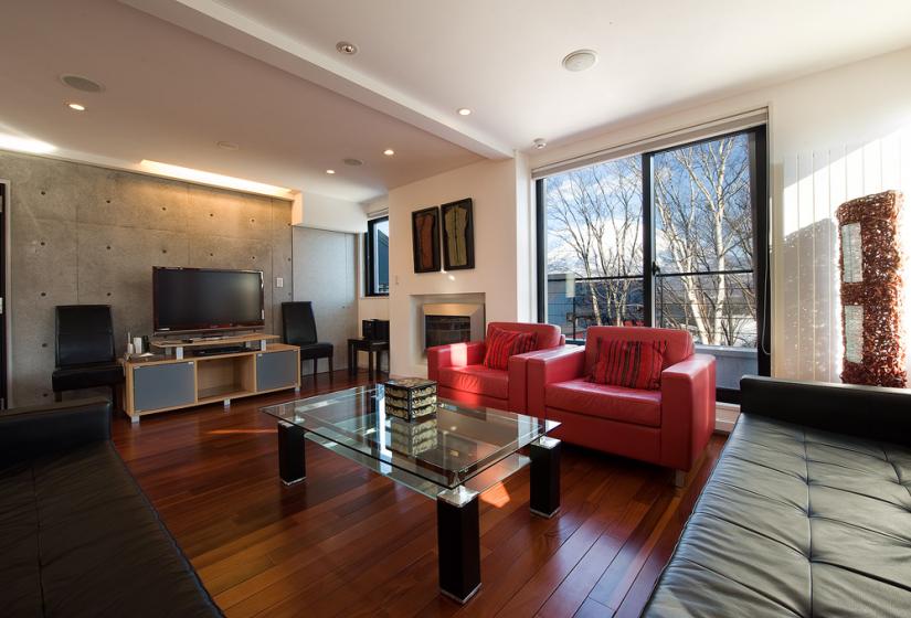 Living area with glass coffee table red leather sofa and yotei view