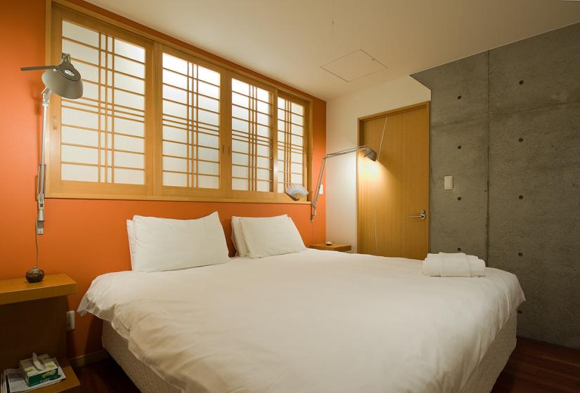 queen bedroom with shoji windows and desk lamp
