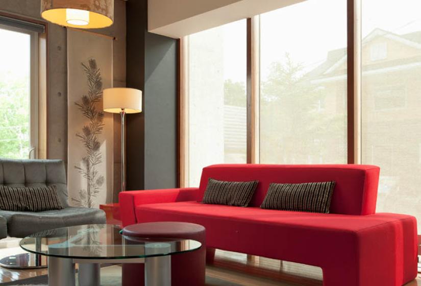 red couch with coffee table lamps and large windows