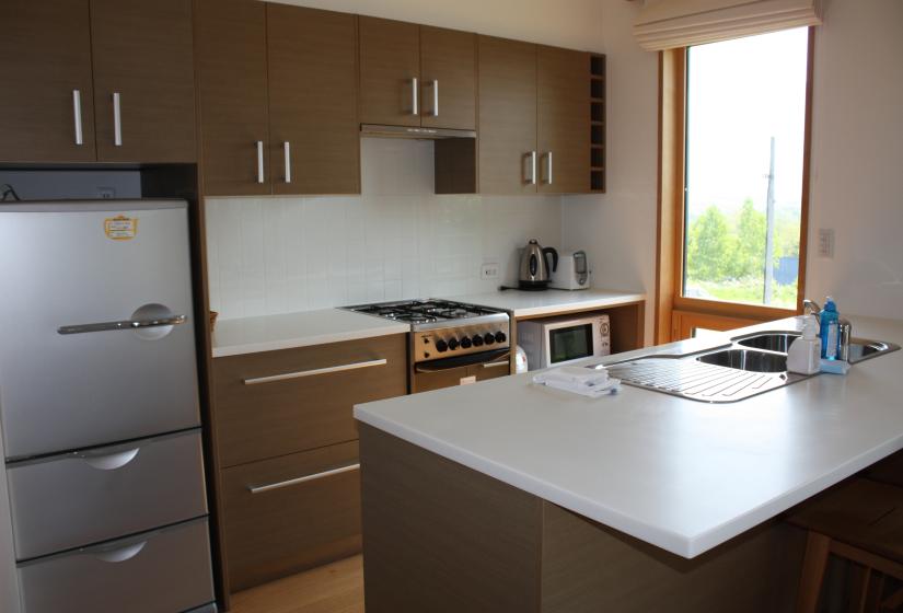 kitchen with large refrigerator, spacious countertops, and stovetop 