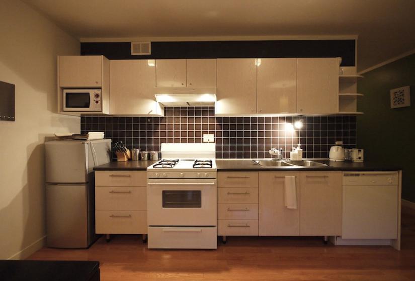 view of kitchen space including refrigerator, oven, stove, and sink