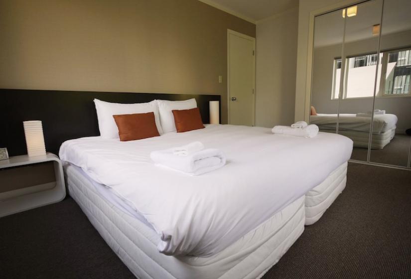 double bed with white bedding and crimson pillows