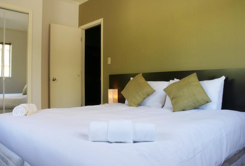 bedroom with white bedding and green pillows