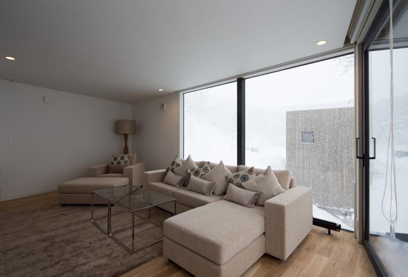 living area with serene winter view behind the sofa