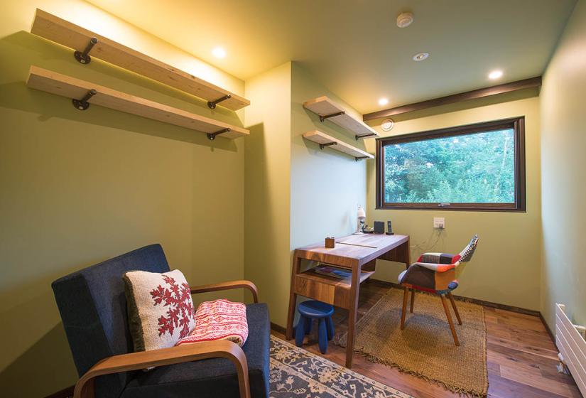 room with couch desk chair and window. green walls