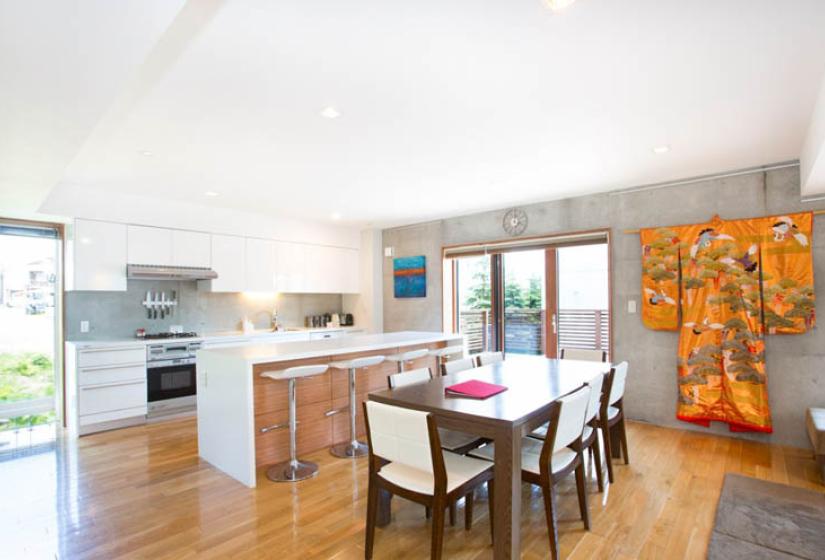 dining table with bar with stools and kitchen in background