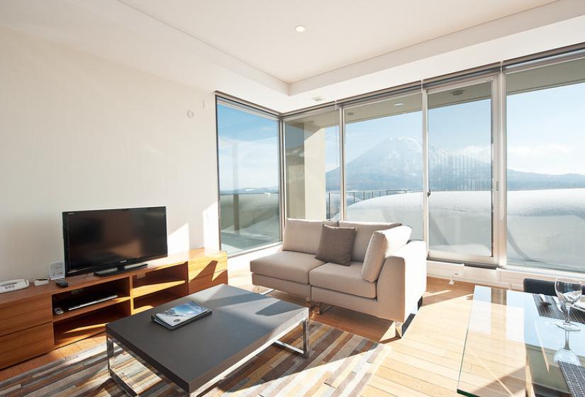 living area with tv large windows and wintertime yotei view