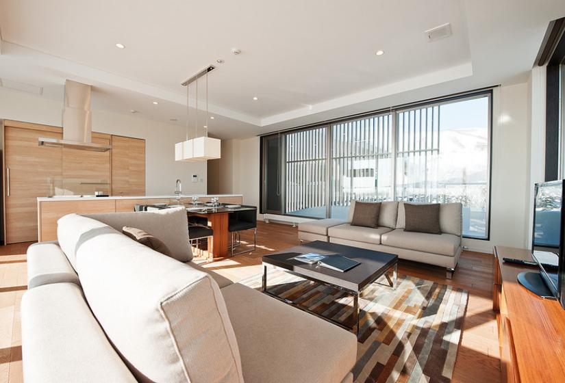 living room with white sofa, hardwood floor coffee table and large windows