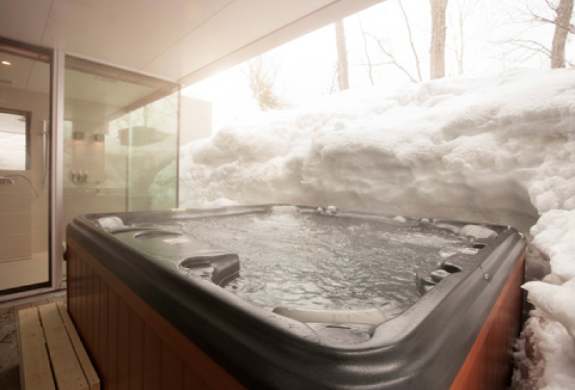 outdoor jacuzzi next to a wall of snow