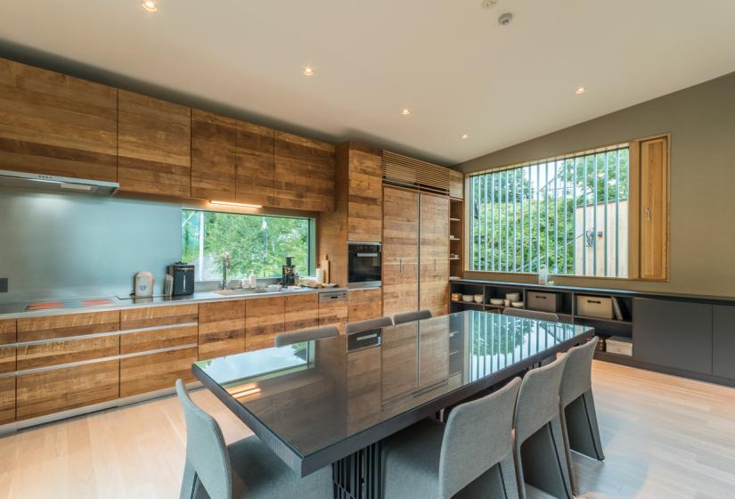 main dining table with wood panelling on walls with window and shades