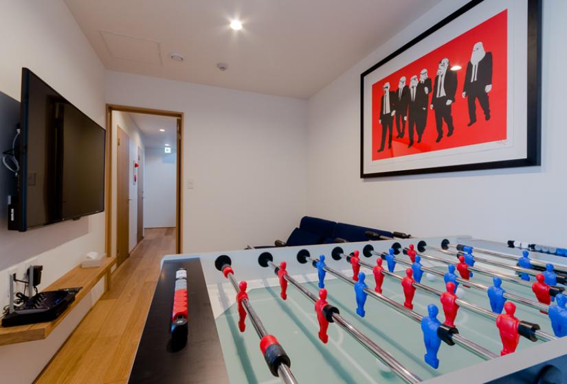 foosball table with framed print on wall with couch