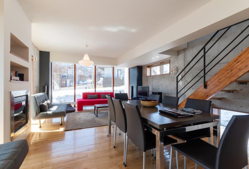 dining and living area with stairs, couch, tv, table, large window views