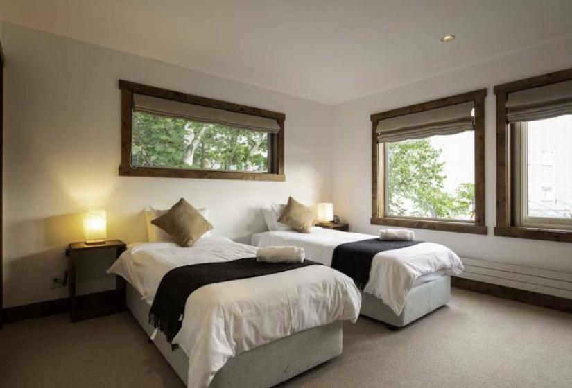 Bedroom 1 Two made up single beds with black throws and brown cushions