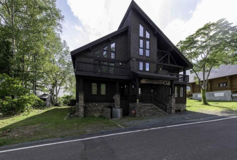 A large wooden building with peaked roof and stone stairway