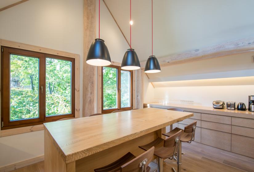 three hanging lights over wooden dining table