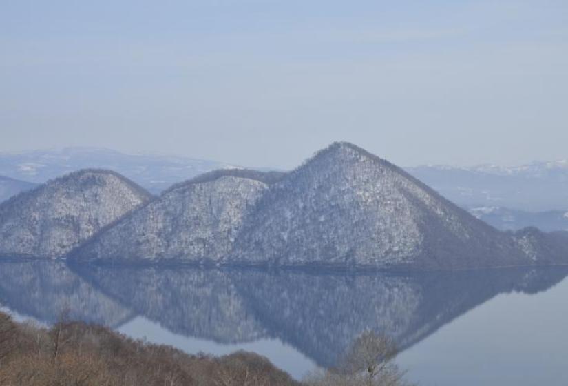 Lake Toya on a calm day, with islands reflected in the lake