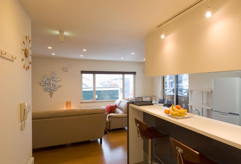 Breakfast bar with bowl of fruit living area in background