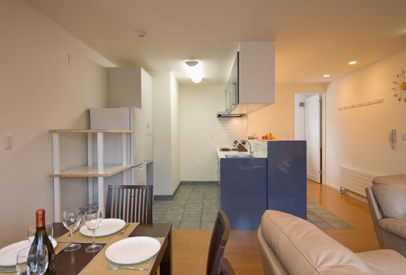 dining table with white plates kitchen in background