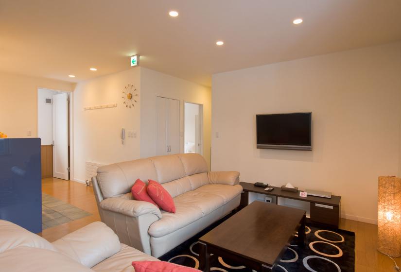 living room with black rug coffee table and flatscreen TV