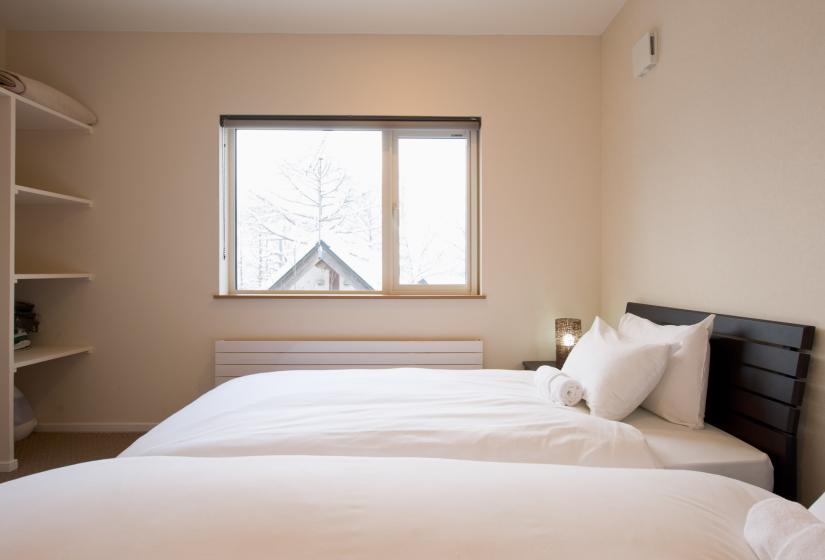 two single white beds with white linen