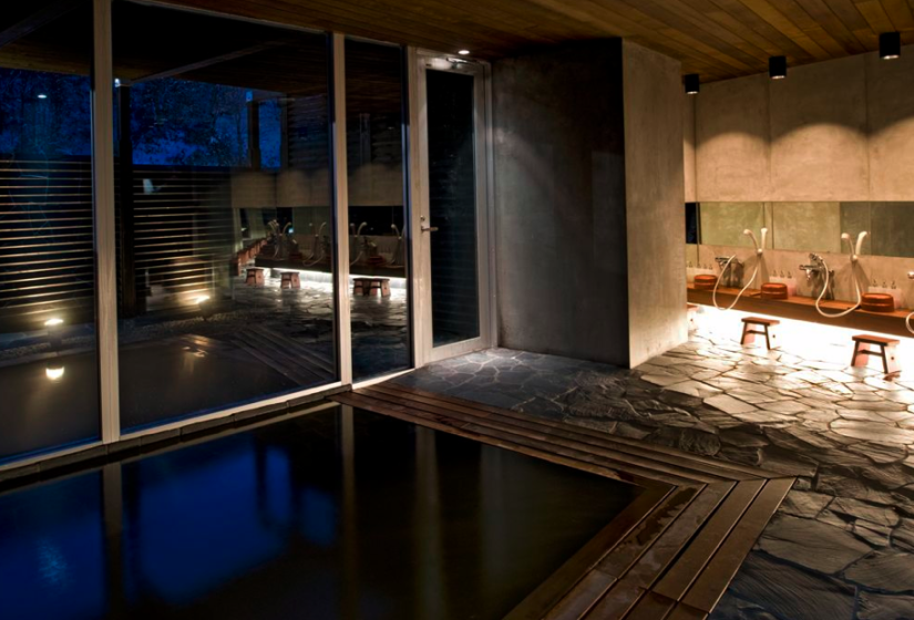 indoor onsen with large windows and door to outside