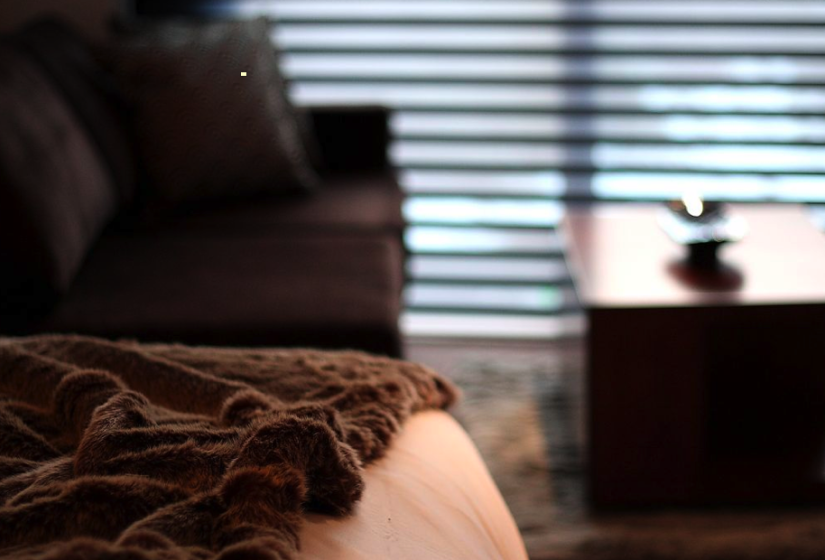 bed cover closeup with couch and table in background