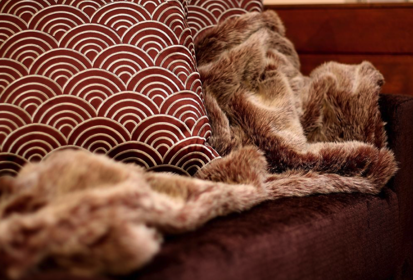 red cloth couch with fur throw blanket
