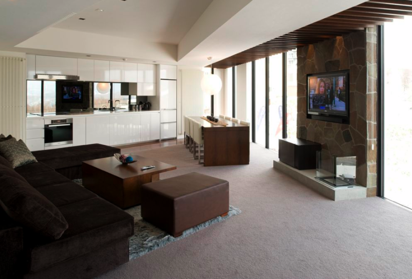 living area with couches, dining table, large windows, and tv