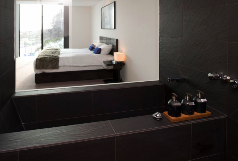 view of king size bedroom from shower with fancy soaps