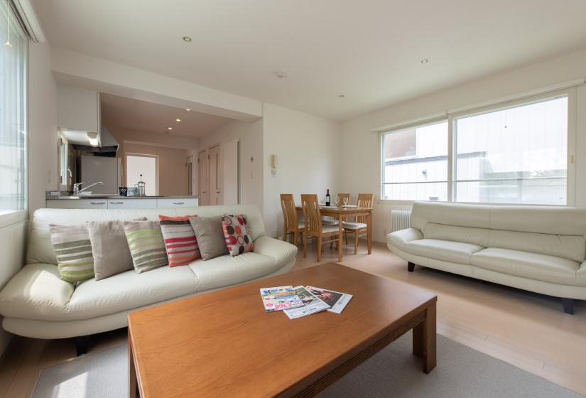 Sakura living room with white couches and dining table