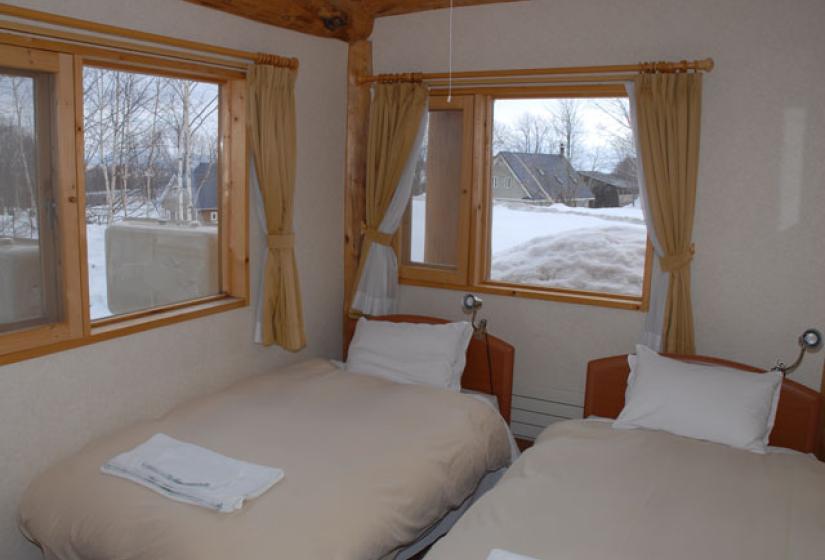 ground floor twin bedroom with exterior windows and curtains