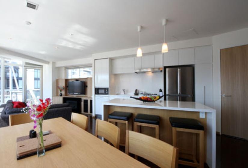 dining room table with tv, kitchen and barstools and island countertop