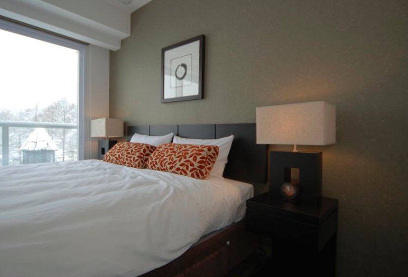 double bed made up in bedroom with green wall