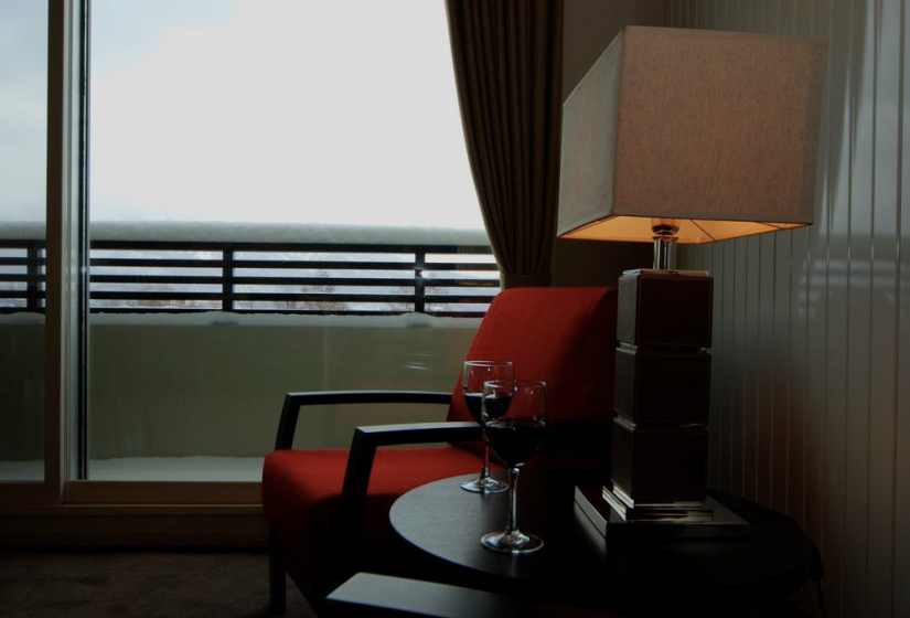 red lounge chair with wine glasses on small table