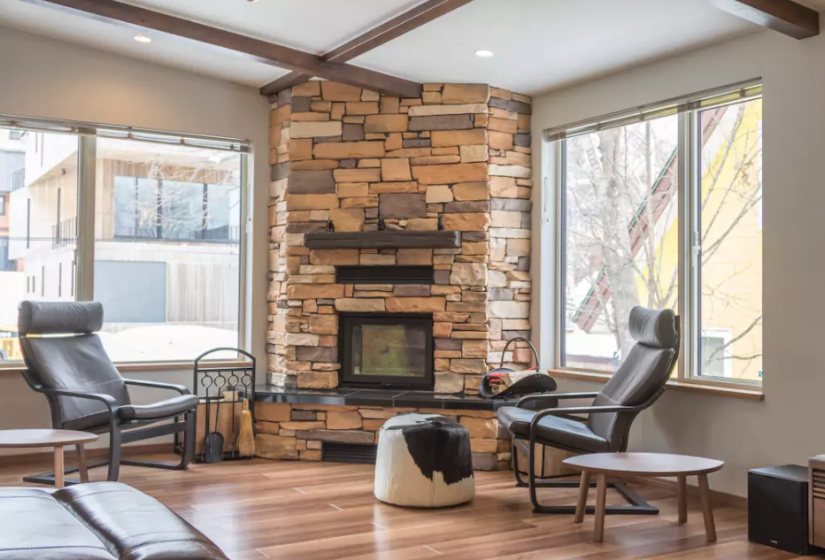 Brick gas fireplace in living area with single black recliner seats