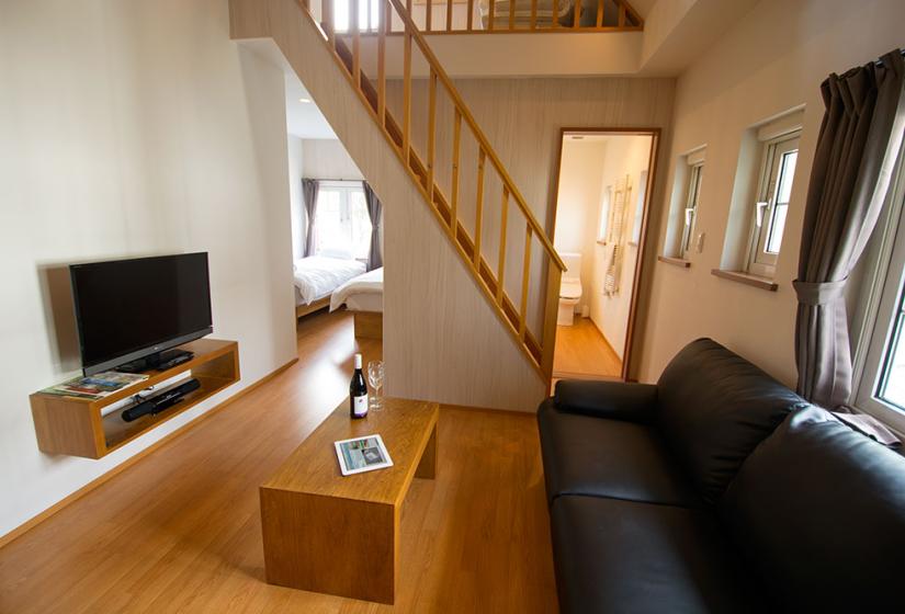 TV lounge area with twin bed alcove and stairs to loft in Snowbird Studio