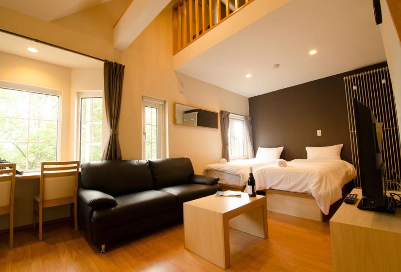 Snowbird studio loft showing sofa, window table, and twin bedding