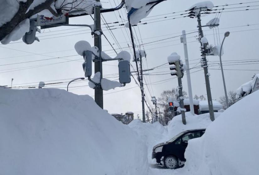 Snow everywhere! A snowy tunnel like foot path with a car at the crossing