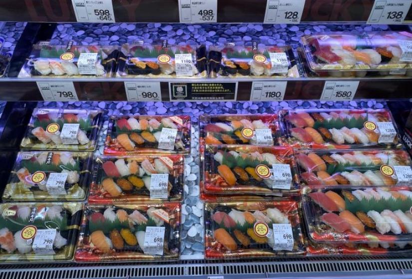 A shelf of supermarket sushi platters