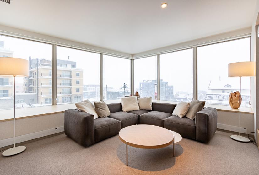 Round coffee table and corner soffe with building back drop