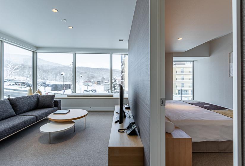 Room with coffee table TV and snowy view from window