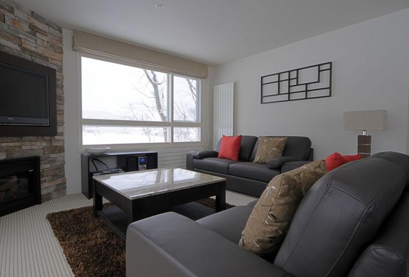 living room with stone coffee table, wall sculpture and trees outside