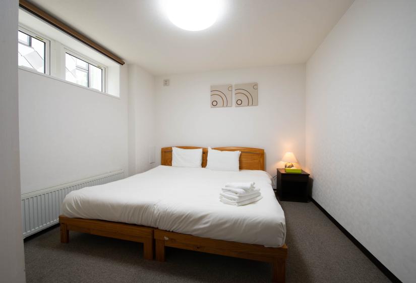 Double bed with white linen and folded white towels