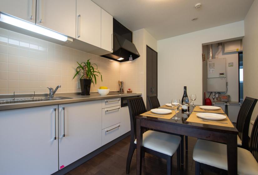 dining table set for dinner with kitchen in background