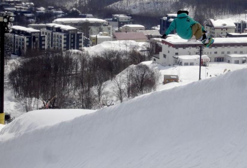 A snowboarder getting air out of the Hirafu Halfpipe