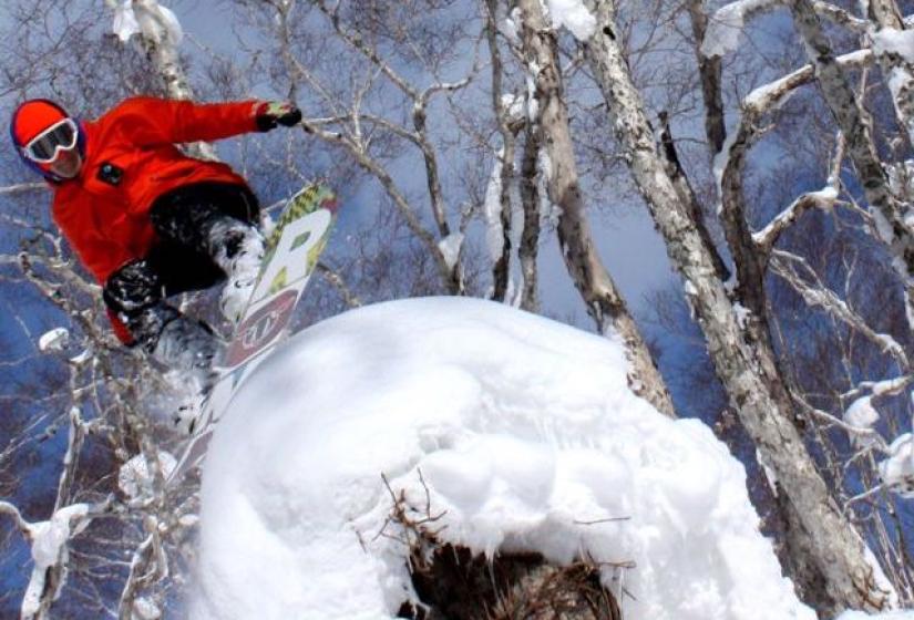 A snowboarder rides accross a snow mushroom