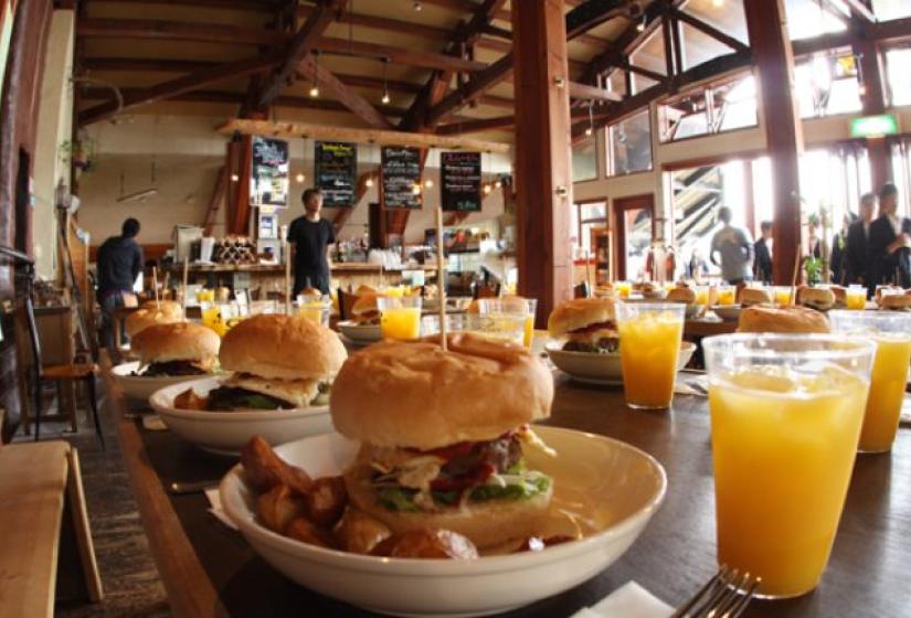 A table of hamburgers and orange juice.  