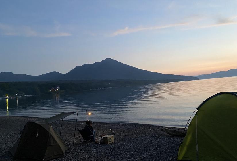Lake Shikotsuko A single camper enjoys a lake view at sunset